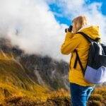 Young blonde photographer takes pictures of Passo Giau pass
